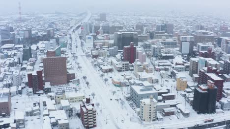 aomori city under snow in japanese winter, aerial tilt reveal of streets