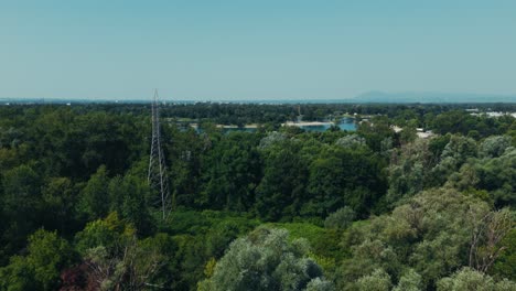 drone shot of lake jarun with tree lined shores, central island, and skyline of zagreb in background