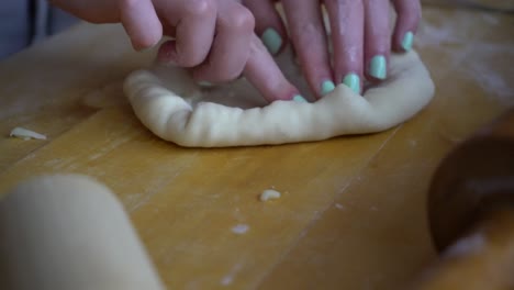 Close-up-of-homemade-mini-stuffed-crust-pizza-being-made-in-kitchen