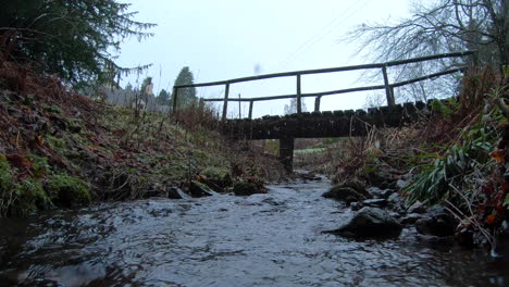 Schneefall-An-Einem-Fluss,-Der-Unter-Einer-Alten-Holzbrücke-In-Einem-Schottischen-Landhaus-In-Der-Region-Kinross-In-Schottland-Fließt