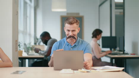 young man working on laptop computer at coworking. joyful man making male
