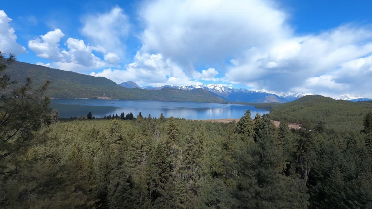 A calm aerial view of Rara Lake in Nepal shows its crystal-clear water surrounded by peaceful hills and Himalayan scenery, highlighting the beauty of this remote high-altitude destination