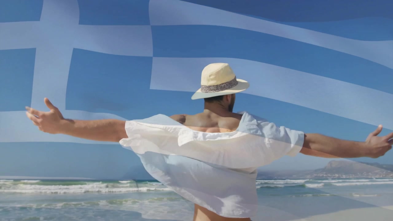 Appassionato di viaggi che arriva su una spiaggia assolata, ruotando verso il cielo con una sovrapposizione della bandiera greca.