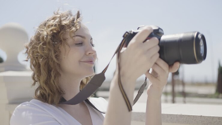 Woman taking photo with camera outdoors