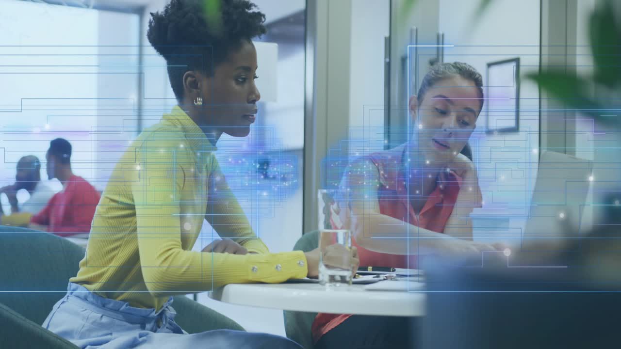 Two women reviewing business documents tapping and typing with holographic grid guiding agreement