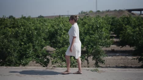 woman walking through an orchard