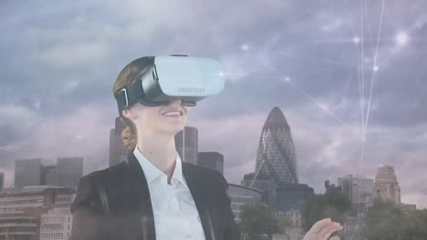 animation of caucasian businesswoman using vr headset and network of connections over cityscape