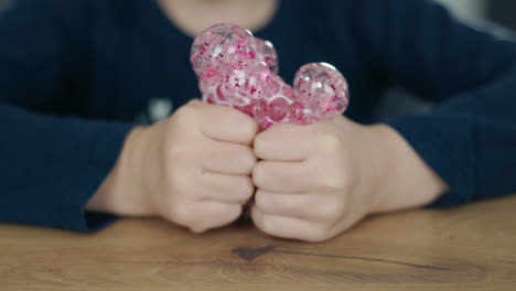 child playing with a pink stress ball