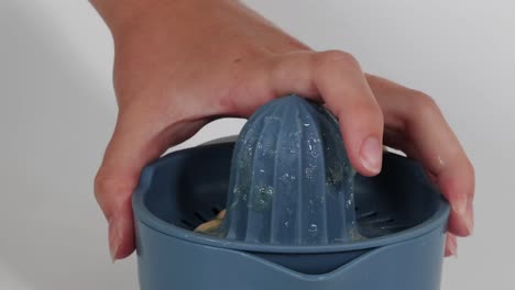 close-up of juice being poured from a manual juicer into a clear glass container.