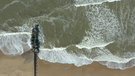 Toma-Aérea-Del-Poderoso-Mar-Y-Sus-Olas-Rompiendo-En-Una-Playa-Desierta-De-Arena-Dorada