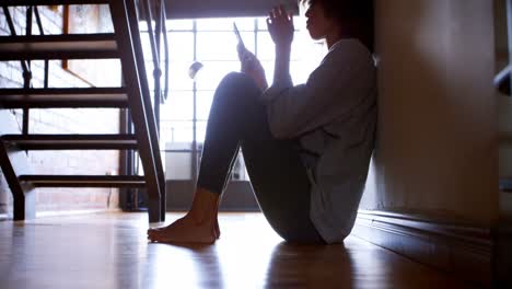 Woman-using-mobile-phone-while-sitting-on-the-floor-4k