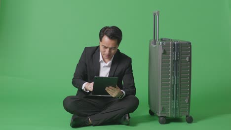 hombre de negocios con tableta y maleta en la pantalla verde