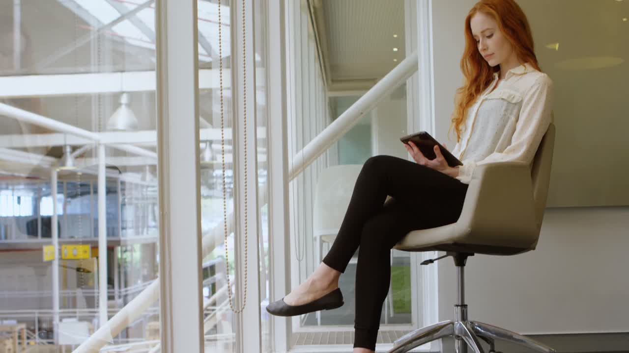 mujer ejecutiva usando tableta digital en la oficina 4k