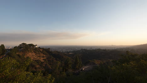 una puesta de sol se convierte en un lapso de tiempo nocturno iluminado por la luna sobre la ciudad de los ángeles como se ve desde las colinas cercanas