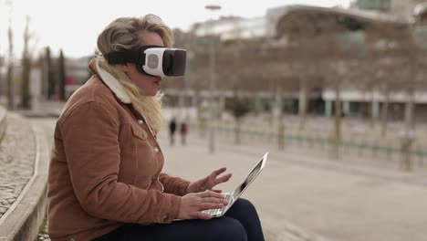 Beautiful-mature-woman-with-laptop-on-her-knees-using-VR-headset