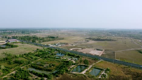 Vista-Aérea-De-Una-Carretera-Rural-De-Cuatro-Carriles-Con-Coches-En-Movimiento