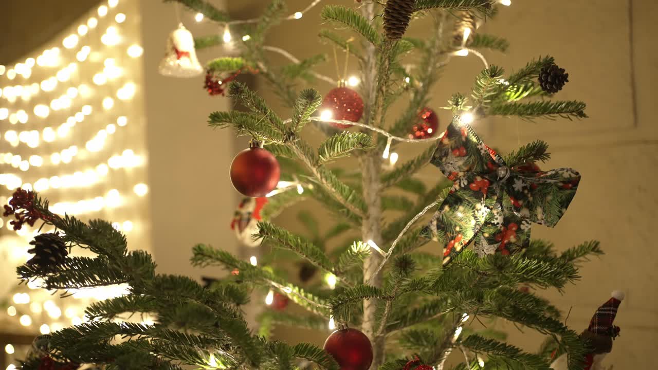 christmas tree with red ornaments and glowing lights set against a warm lit background