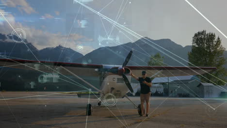 man standing by small airplane with data processing animation over mountains