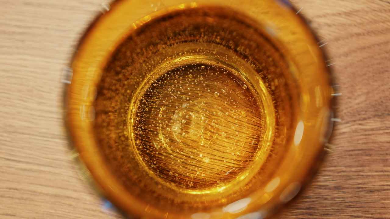 Primo piano di acqua frizzante in un bicchiere giallo su un tavolo al ristorante