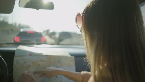 couple pointing at map in car