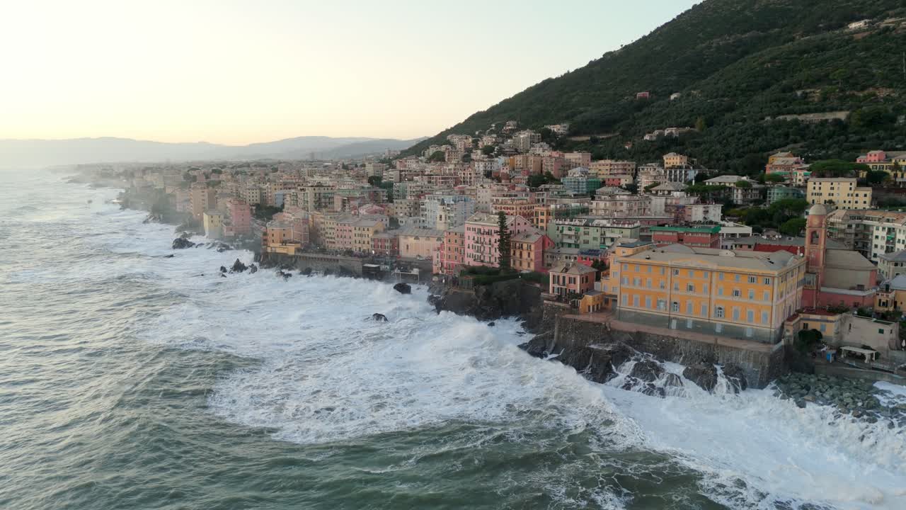 Grandi onde marine spumeggianti che si infrangono sulla costa della città, quasi raggiungendo le case.
