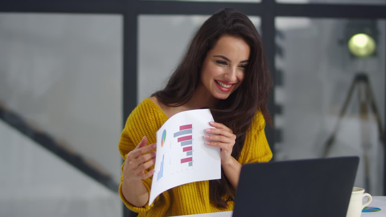 Smiling businesswoman showing charts and graphs on video call in slow motion