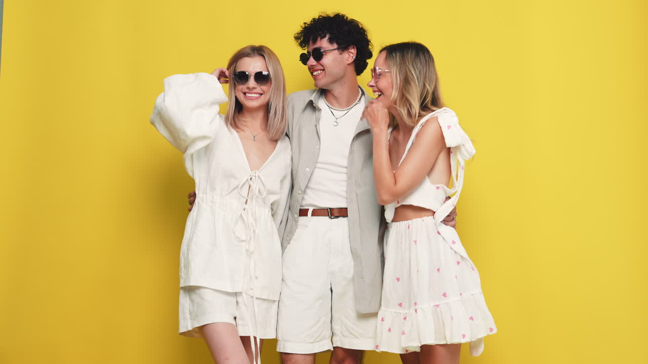 tres amigos posando contra un fondo amarillo brillante