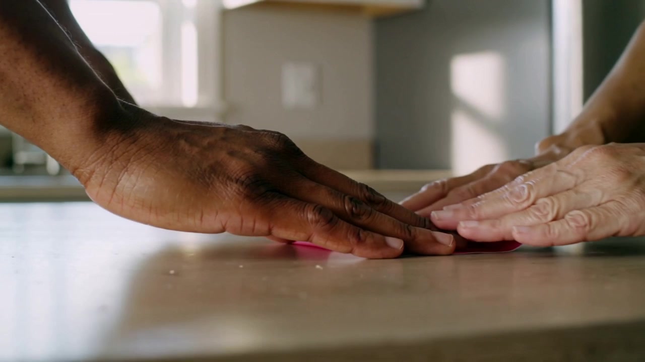 Posizionamento di cuori rosa e bianchi, entrambe le mani premono, levigando sul bancone di casa per appiattire la creazione artigianale