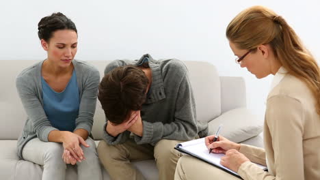 young unhappy couple talking with their therapist