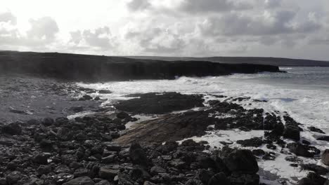 Antenne-Des-Stimmungsvollen-Schwarzen-Strandes-In-Irland-Mit-Großen-Klippen-Im-Hintergrund