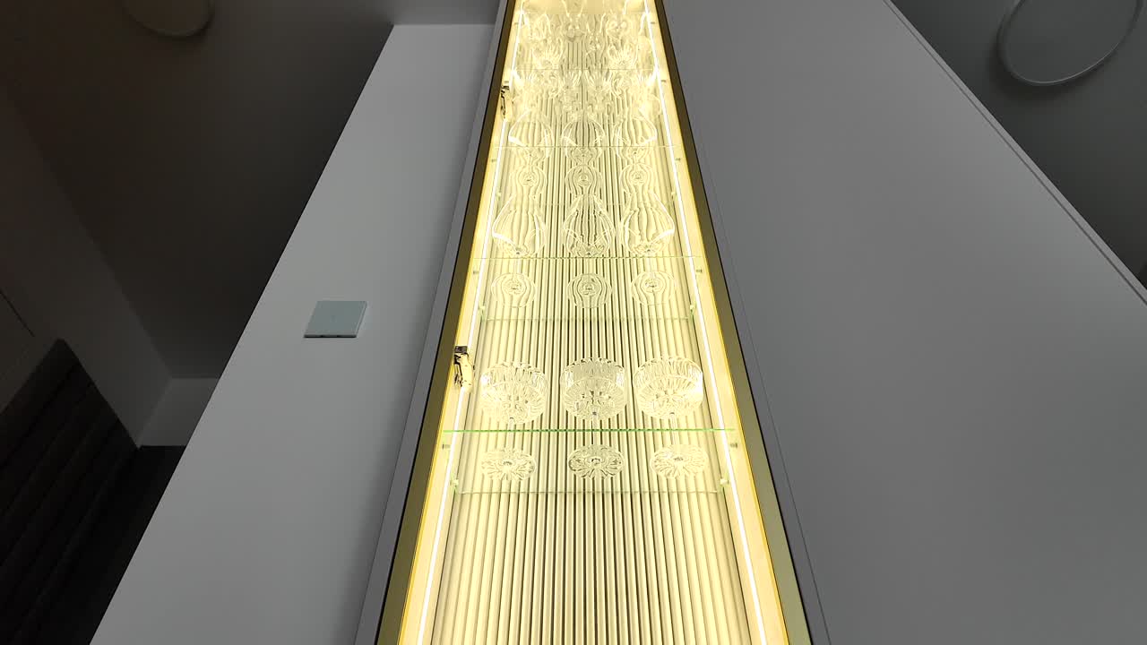Luxurious alcohol cabinet, gold backlit. Slow motion video. Real estate.