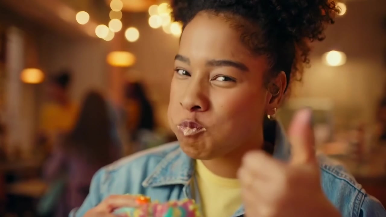 Young Woman Enjoying a Colorful Rainbow Burger in a Restaurant