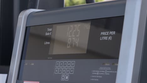 medium close shot of a gas station pump as the numbers rise while filling up the gas tank