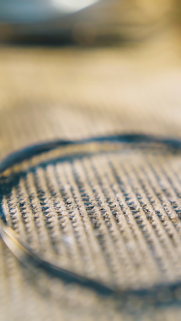 CU: motion past gold wire ring heated with gas burner flame on insulation cover in light jewelry workshop close view