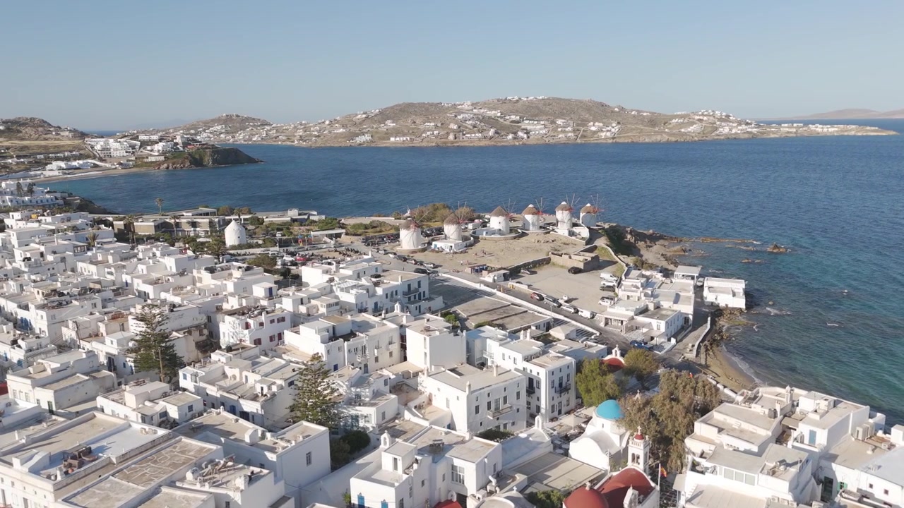 Vista aerea panoramica della città di Mykonos con i famosi mulini a vento e le case bianche sul Mar Egeo.