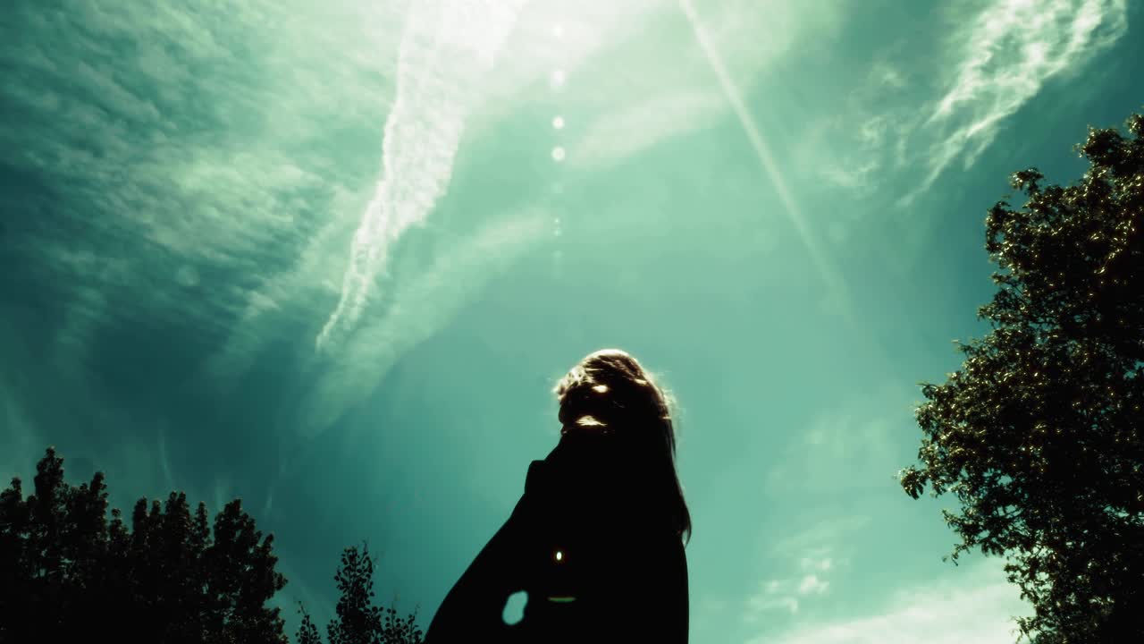 Silhouette of female graduate student throwing cap into the air and jumping excitedly. Shot in glorious slow motion.