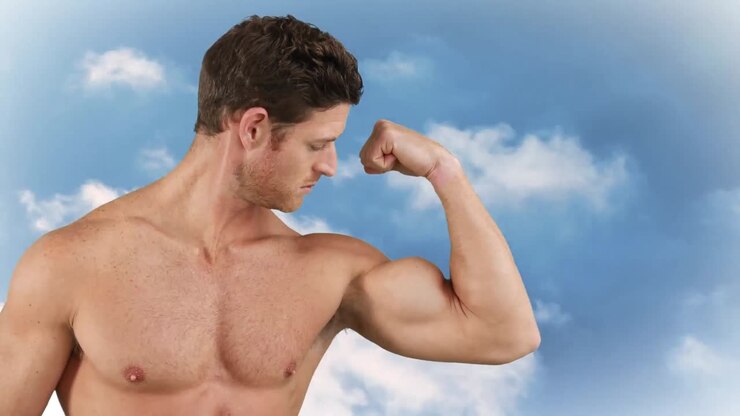 Man flexing his biceps on a sky background