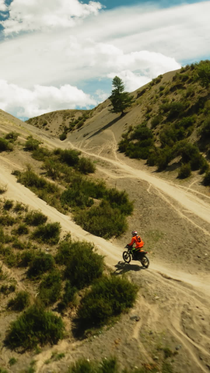 el motociclista sube cuesta arriba adelantando al competidor fpv. el piloto maniobra en terrenos difíciles fuera de carretera en carreras extremas. sensación de velocidad y libertad