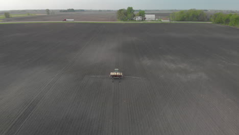 Aerial-drone-shot-of-a-farmer-spraying-a-field