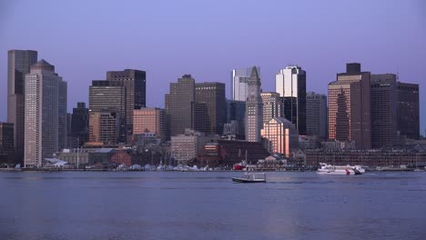 Horizonte-Del-Centro-De-Boston,-Massachusetts-Con-Taxi-Acuático-Por-La-Noche-O-Al-Anochecer