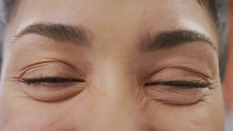 close up portrait of eyes of happy biracial female doctor smiling and looking to camera