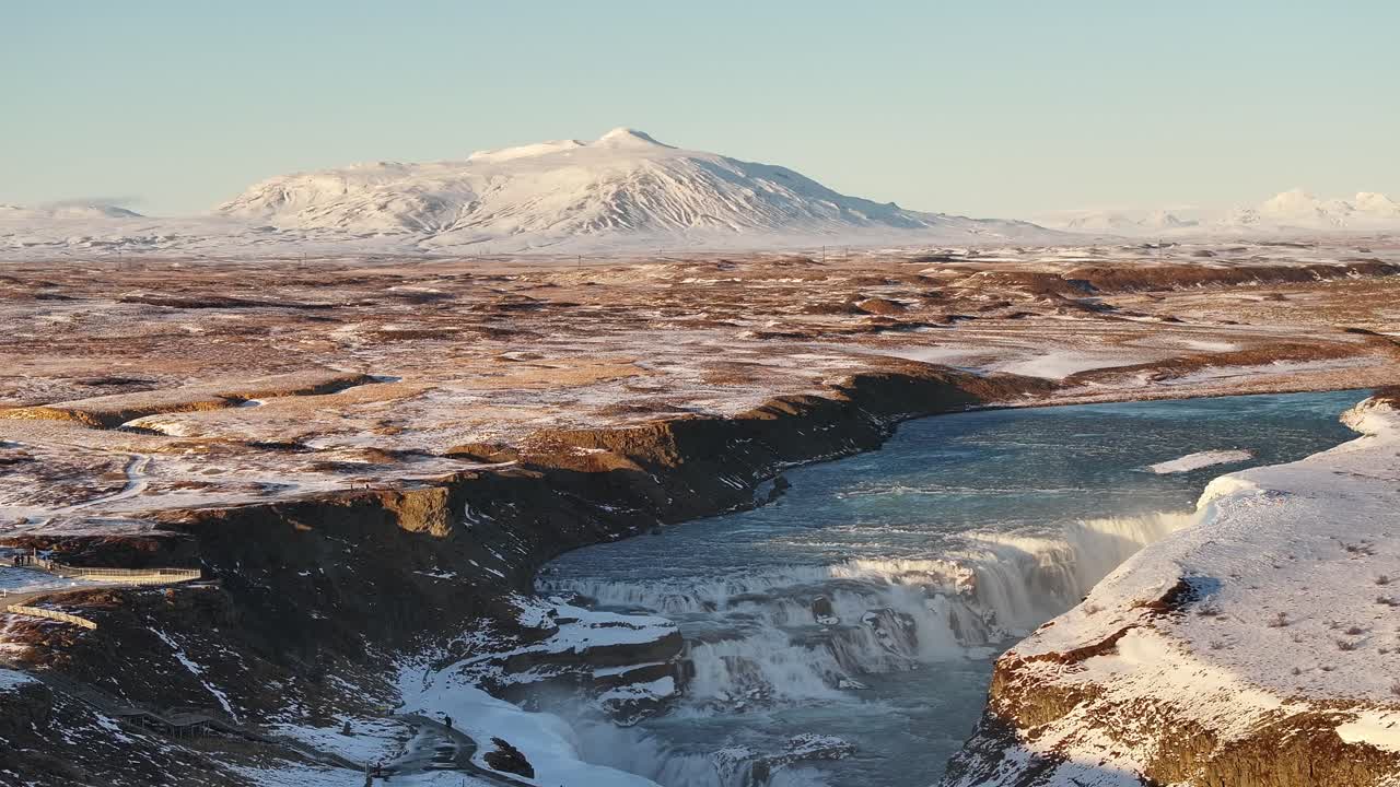 Spectacular aerial view of Gullfoss waterfall, Iceland, surrounded by snow-covered terrain.