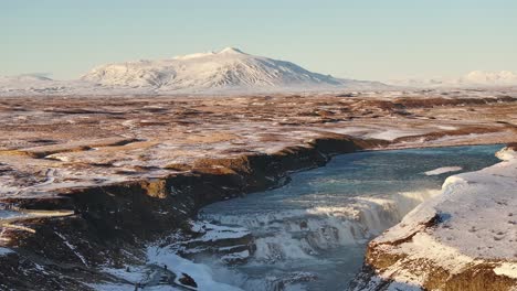 spectacular aerial view of gullfoss waterfall, iceland, surrounded by snow-covered terrain.