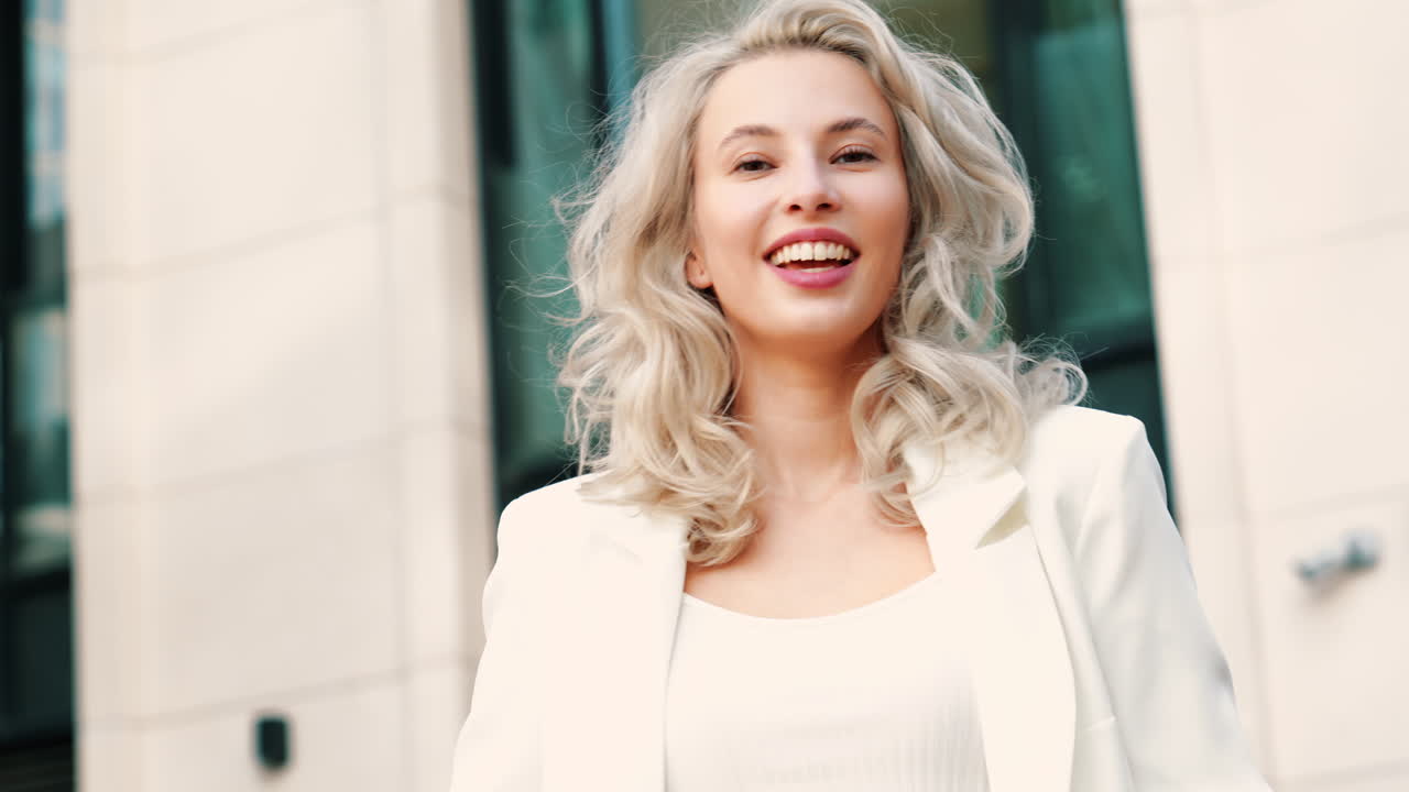 улыбающаяся женщина в белом блейзере