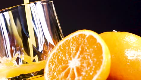 juice pouring into glass with fresh oranges