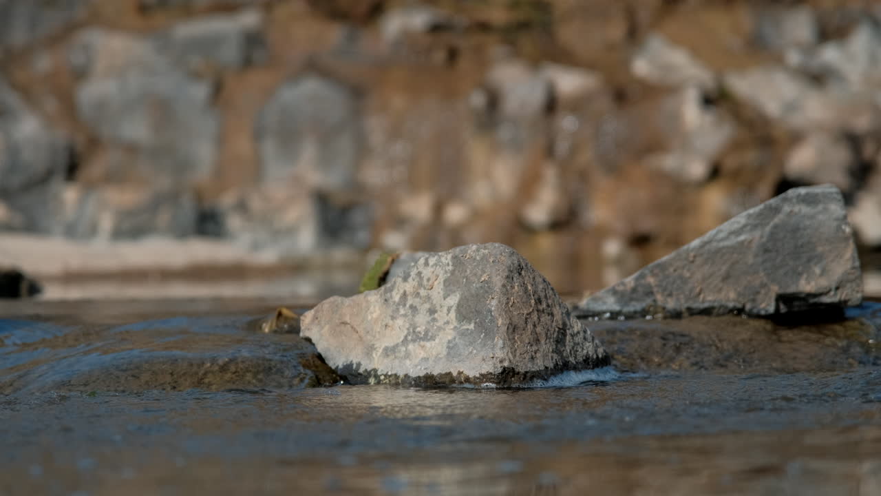 Primo piano di pietre in un corso d'acqua in una giornata di sole.