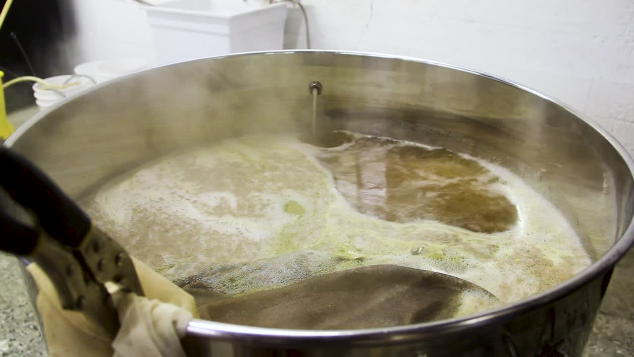 Alcoholic Beer Frothing and Steaming in Pot at Local Brewery