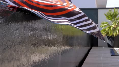 Slow-descending-shot-of-water-flowing-over-the-side-of-a-pool-in-Sete