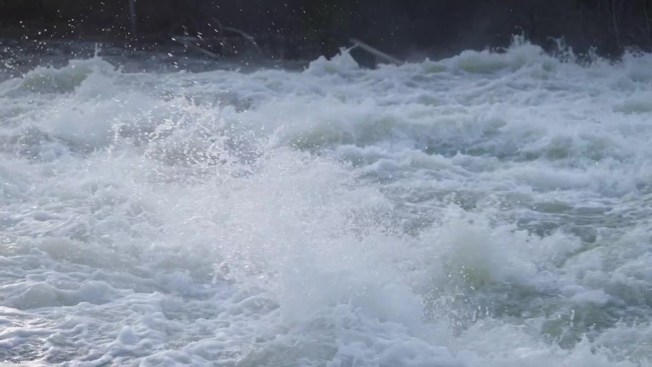 Stark turbulente Fluss-Stromschnellen wirbeln heftig und erzeugen dichte Muster aus weißem Schaum
