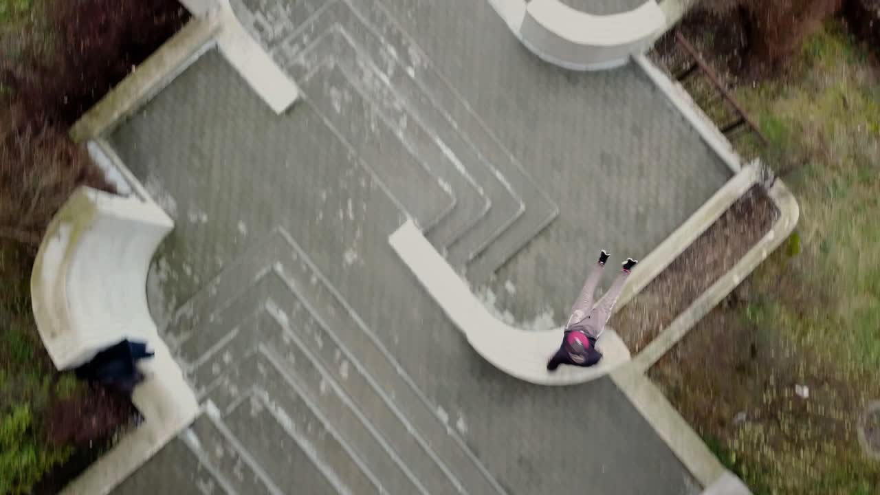 toma aérea de un dron de un corredor libre de parkour macho adulto joven que salta sobre las paredes